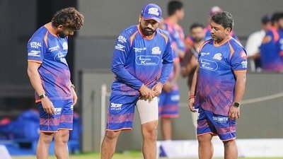 Rohit Sharma is attended to by MI's medical and support staff, with heavy strapping on his left thigh. (PTI)