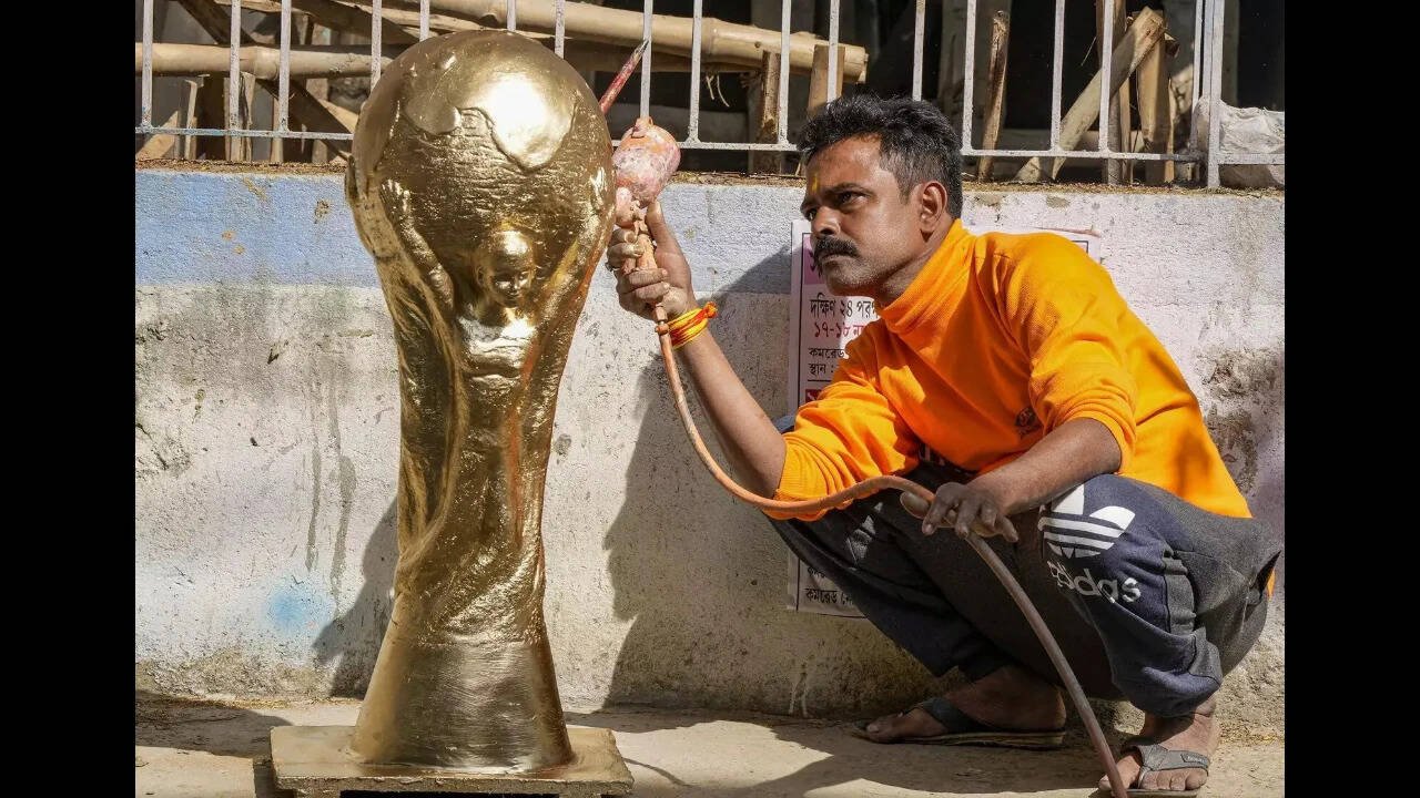 Kolkata_ An artisan paints a clay model of FIFA World Cup trophy at his workshop