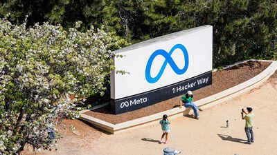 FILE - Visitors take photos at a sign outside Meta headquarters March 26, 2026, in Menlo Park, Calif. (AP Photo/Noah Berger, File) At Meta offices, flyers from angry employees appear in meeting rooms, toilets, and vending machines that say: Don't want to...
