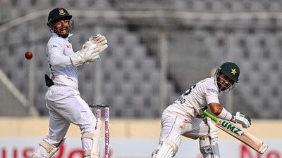 Pakistan's Mohammad Rizwan (R) watches the ball after playing a shot as Bangladesh's wicketkeeper Litton Das reacts during the fifth day of the first Test (AFP)