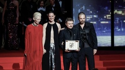 Director Cristian Mungiu, Palme d'Or award winner for the film Fjord, pose next to cast members Renate Reinsve, Sebastian Stan and Tilda Swinton, on stage during the closing ceremony of the 79th Cannes Film Festival. (REUTERS/Sarah Meyssonnier)