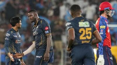 Gujarat Titans' Jason Holder interacts with captain Shubman Gill, left, during the match against Punjab Kings. (PTI)