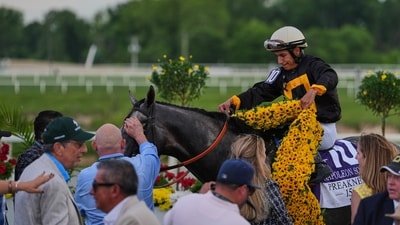Paco Lopez drapes a blanket of Black-eyed Susan flowers over Napoleon Solo after winning the 151st running of the Preakness Stakes horse race. (AP Photo/Julia Demaree Nikhinson)
