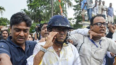 TMC General Secretary Abhishek Banerjee wears a helmet after stones and eggs were hurled at him during his visit to meet families of post-poll violence victims, in Sonarpur, West Bengal. (PTI) TMC General Secretary Abhishek Banerjee wears a helmet after stones and eggs were hurled at him during his visit to meet families of post-poll violence victims, in Sonarpur, West Bengal. (PTI)