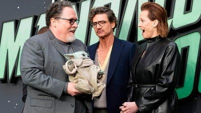 Director Jon Favreau, holding Grogu, alognside Pedro Pascal and Sigourney Weaver, posing for photographers upon arrival at the Star Wars: The Mandalorian and Grogu fan event in London. (Scott A Garfitt/Invision/AP)