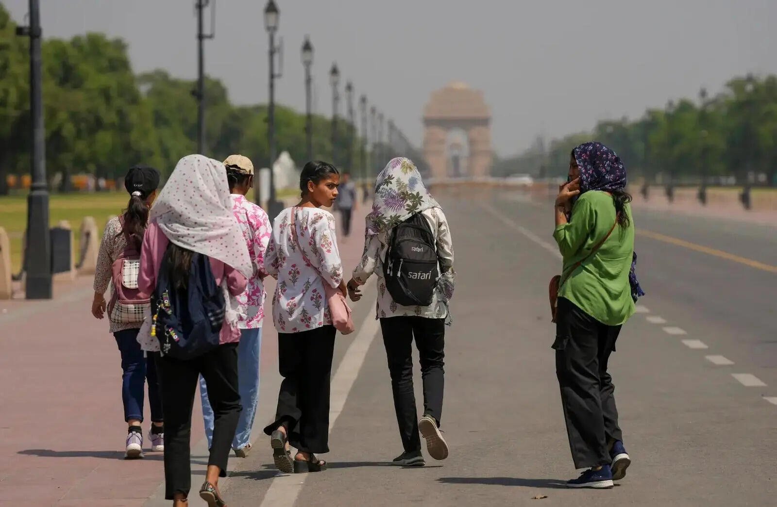 Pedestrians cover their heads to protect themselves from the scorching heat (Image/PTI)