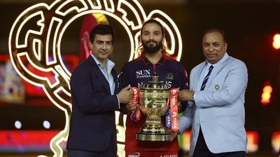 Royal Challengers Bengaluru's Rajat Patidar celebrates with the trophy after winning the IPL alongside BCCI president Mithun Manhas and BCCI Secretary Devajit Saikia (REUTERS)