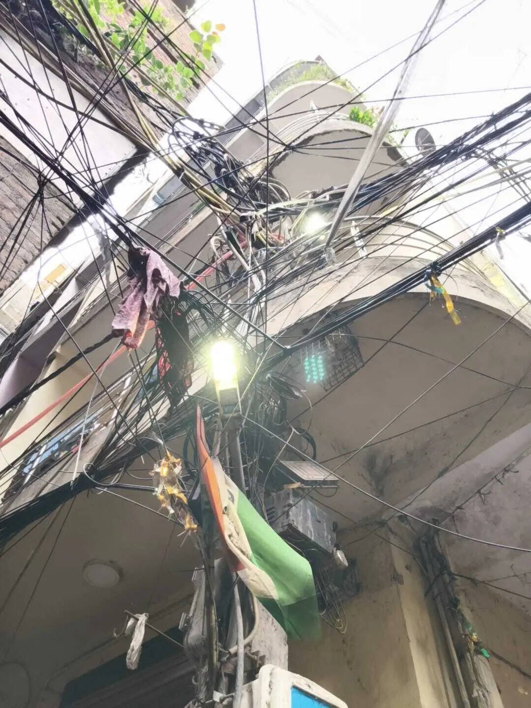An electric pole passing through the balcony of a residential building.