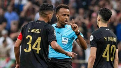 Referee Omar Artan, center, of Somalia, is confronted by players after calling a penalty kick during the CAF Champions League final soccer match between AS FAR Rabat and Mamelodi Sundowns, in Rabat, Morocco, Sunday, May 24, 2026. (AP Photo) FIFA World Cup: Somali referee who was denied US entry had suspected 'terror' links