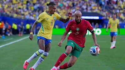 Brazil's Raphinha, left, and Morocco's Noussair Mazraoui go for the ball during the World Cup Group C football match between Brazil and Morocco in East Rutherford, N.J., near New York, Saturday, June 13, 2026. (AP Photo) FIFA World Cup: Morocco script history vs Brazil, become first football team ever to ...
