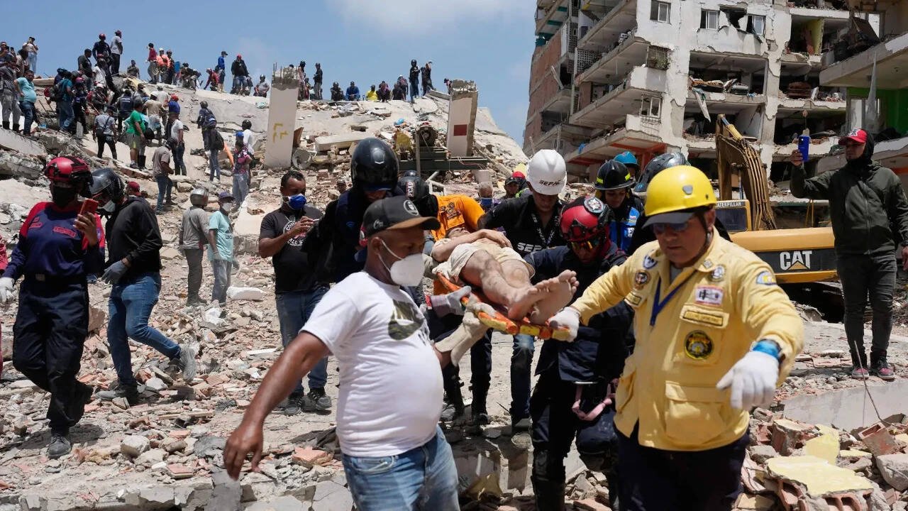 Rescue workers carry a survivor after pulling him from the rubble two days after an earthquake struck Catia La Mar, Venezuela. Photo Credit: ANI