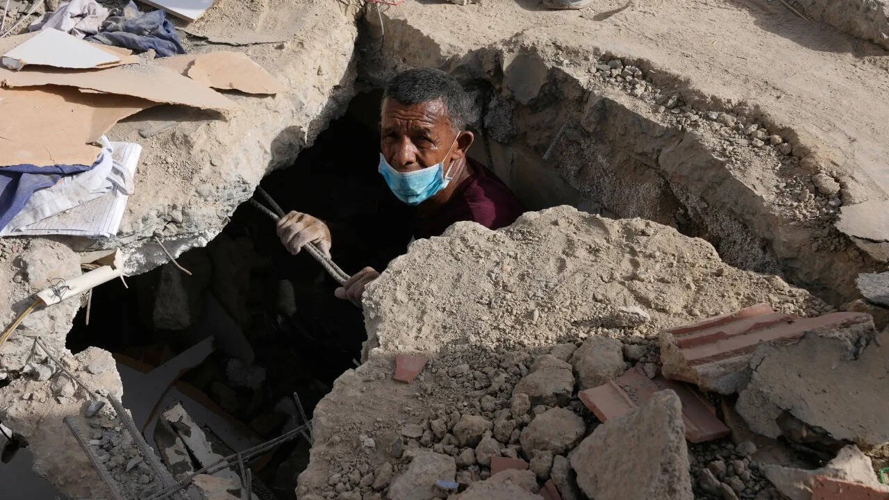 Survivor search for missing relatives in the collapsed building where they lived two days after earthquakes struck La Guaira, Venezuela. Photo credit: AP