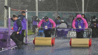 Workers try to dry the track as the rain interrupts the women's high jump final at the Commonwealth Games in Glasgow. (AP Photo) Explained: Why rain can't stop athletics at CWG 2026 despite safety concerns