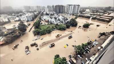 A creek overflows into surrounding residential areas in Surat on Wednesday 13 killed in Surat rains: Floodwaters continue to inundate homes, markets and roads