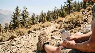 A lone hiker suffering from heat exhaustion on a steep forest trail in the Adirondack Mountains. US summer heat triggered multiple dehydration emergencies in New York's Adirondacks, where hikers needed airlifts, IV fluids and overnight rescues