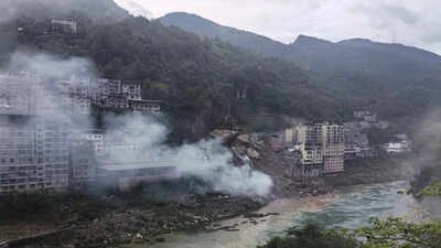 Footage aired by CCTV showed a section of the hillside collapsing onto a cluster of riverside homes (AP photo) Several trapped after landslide buries homes in China's Chongqing