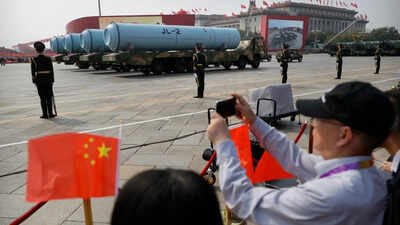 File photo - Spectators wave Chinese flags as military vehicles carrying JL-2 submarine-launched missiles roll during a parade(Picture credit: AP) A missile launch, a nuclear message: Why China wanted the US to take notice