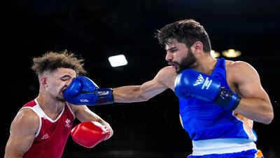 India's Sachin Siwach, in blue, competes against Canada's Keoma Al-Ahmadieh. (PTI Photo) CWG 2026 Day 3: No medals for India, but Sachin Siwach advances and Rupa-Pinki stay unbeaten