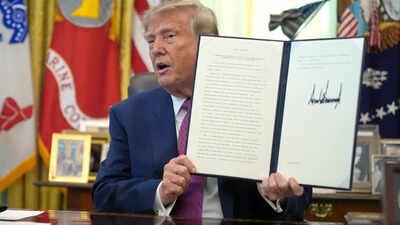 US President Donald Trump holds up a signed executive order in the Oval Office of the White House (AP photo) Donald Trump changes Lake Ontario’s name to ‘Lake America’ amid tensions with Canada