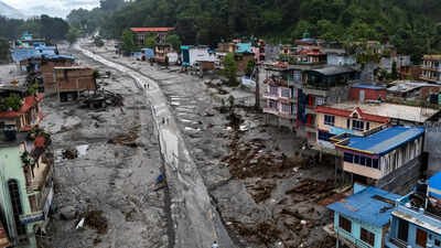 A drone view shows people walking on a mud-covered road next to damaged houses following deadly flash floods and mudslides in Nepal (Reuters photo) Nepal-Tibet floods: 750 dead, 20,000 deployed as rising rivers hamper rescue ops - top developments