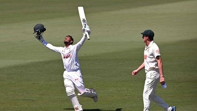 Tanzid Hasan celebrates scoring his century as Pat Cummins looks on. (AFP)