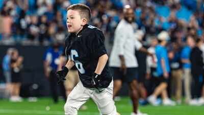 Asher scored a touchdown after taking a handoff from Bryce Young. Born with a complex heart condition, a 6-year-old signed with the Carolina Panthers for one day and scored a touchdown in an NFL stadium