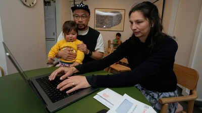 Woman logs onto the census website as her husband holds their daughter while their son plays behind them, in Sydney. (Photo: AP) Australia census asks about sexual orientation, gender for first time