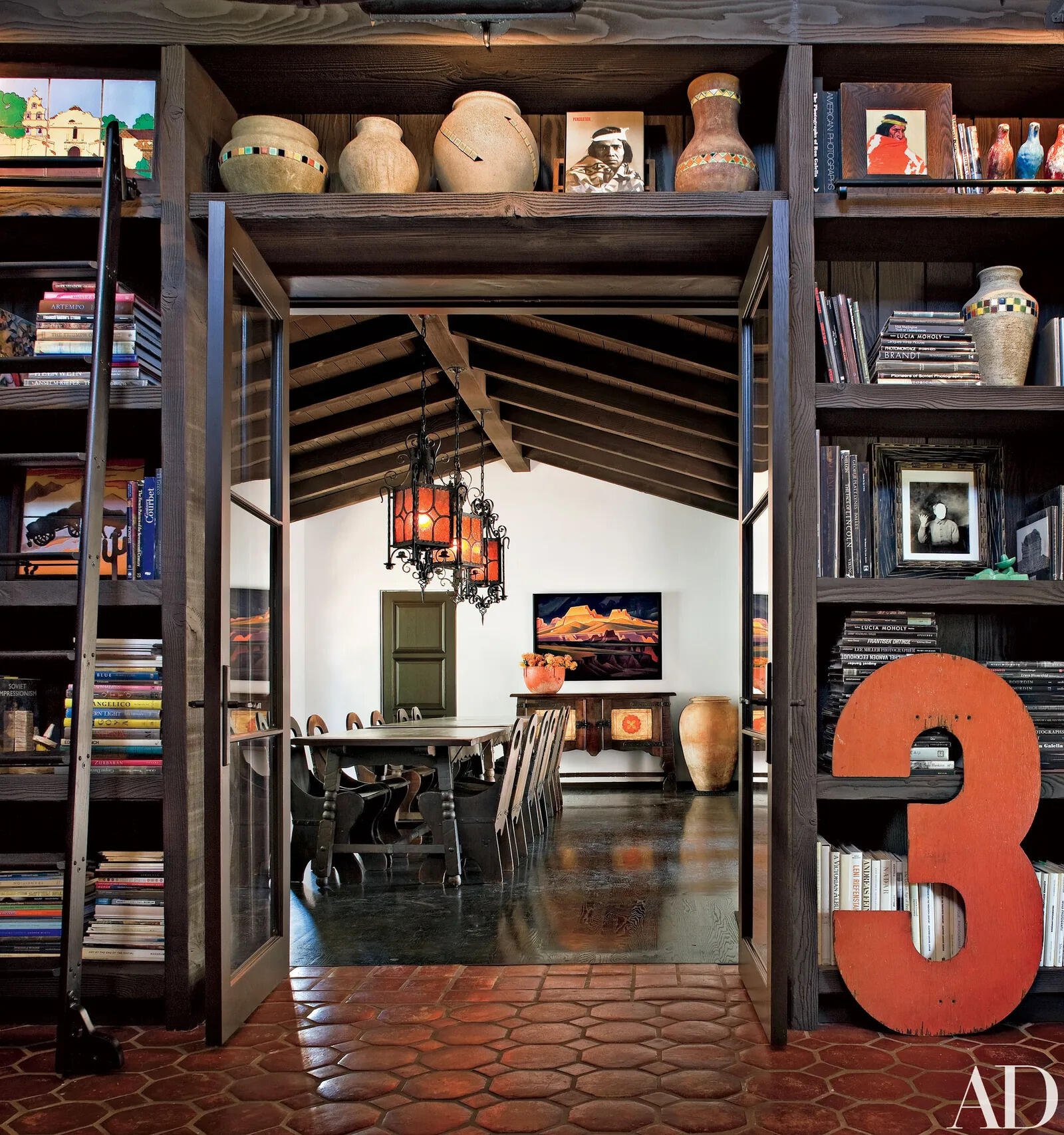 The formal dining room combines Spanish-inspired light fixtures with French doors opening onto a cozy courtyard, creating a sophisticated indoor-outdoor entertaining space.