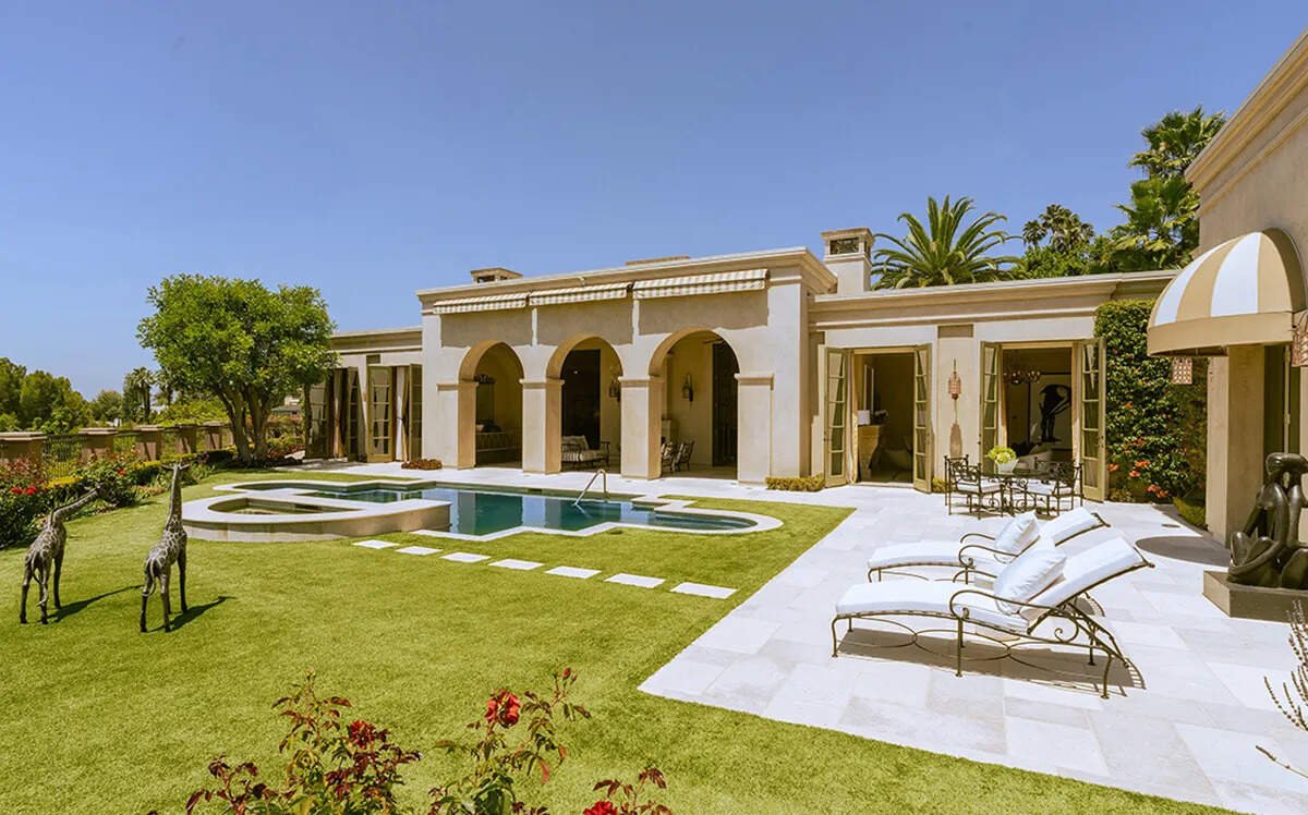 The nearly one-acre grounds include a freeform pool, spillover spa, sundeck and manicured lawns.
