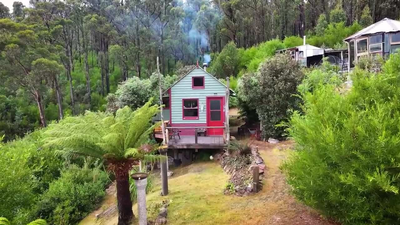 She Bought 25 Acres at 21. After the Bushfire, She Built This Cabin From What Survived At 21, an Australian artist bought 25 acres in Tasmania; 18 months later a bushfire destroyed her first home, so she rebuilt it from salvage materials into an off-grid cabin for AU$7,000-10,000