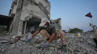 A volunteer searches through the rubble of Shajareh Tayyebeh school, shattered by a U.S. airstrike on Feb. 28, in Minab Did AI-enabled ‘kill chain’, outdated intel lead to deadly Iran school strike? What report claims