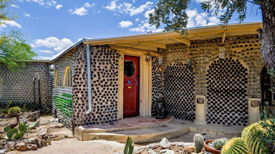 Main entrance of the constructed bottle and rock home (Source: Coldwell Banker Realty) In 1964, an Arizona couple began building a carport with discarded bottles; years later, the project had grown into a 2,700-sq-ft home made with thousands of bottles and listed for $432,500