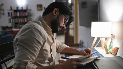 Indian filmmaker Shaunak Sen reading notes from a diary at his residence in New Delhi. (Photo by Arun SANKAR / AFP) (AFP) Indian filmmaker Shaunak Sen reading notes from a diary at his residence in New Delhi. (Photo by Arun SANKAR / AFP) (AFP)