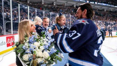 Goaltender Connor Hellebuyck #37 of the Winnipeg Jets takes daughter Violet, as he presents his wife Andrea with flowers during a pre-game ceremony celebrating recent milestones of 500 games played, 300 wins and 40 career shutouts prior to NHL action against the Los Angeles Kings at the Canada Life Centre on January 10, 2025 in Winnipeg, Manitoba, Canada. (Photo by Jonathan Kozub/NHLI via Getty Images) Did Olympic fallout involving Connor Hellebuyck’s wife push the NHL star toward a Winnipeg Jets exit