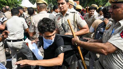 Police personnel detain Cockroach Janta Party (CJP) supporters CJP protesters enter gurdwara to evade police detention in Delhi, don cockroach helmets