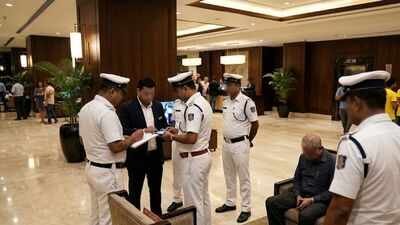 Cops can be seen talking to a man in a hotel lobby. (AI image) Noida 'sex pest' held at Kolkata hotel after Brazil match