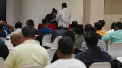 Caddell workers gather in a hotel conference room to wait their turn to sign an agreement for compensation from the company (AP photo) Milan US consulate labour 'exploitation' case: Indian workers among hundreds agree to share of $35m payout